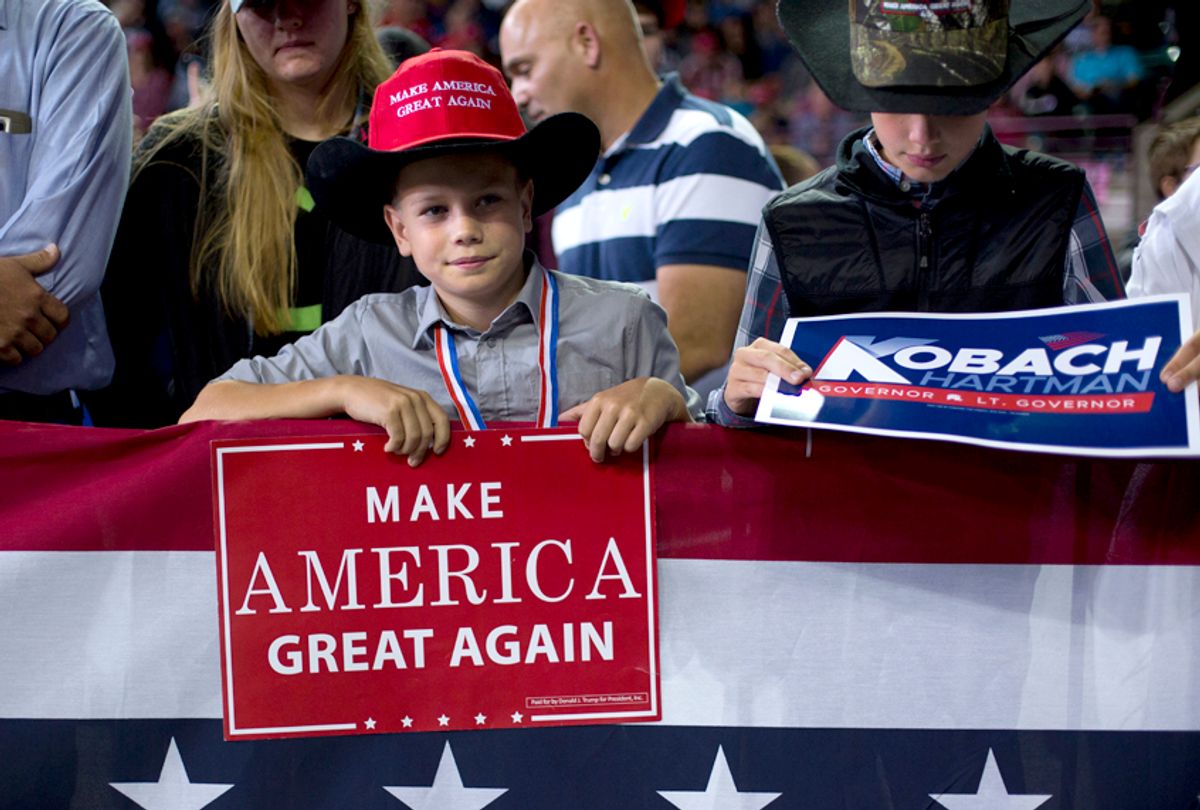 Two young supporters hold campaign signs as they wait to hear President Donald Trump speak at a campaign rally at Kansas Expocentre, Oct. 6, 2018 in Topeka, Kan.  (AP/Pablo Martinez Monsivais)