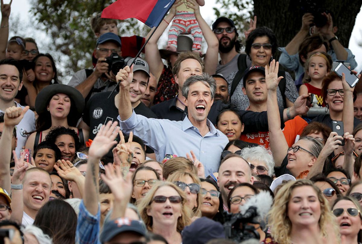 U.S. Senate candidate Rep. Beto O'Rourke (D-TX) holds a Texas flag as he poses for a group photo with supporters during a campaign rally in Mueller Lake Park October 31, 2018 in Austin, Texas.  (Getty/Chip Somodevilla)