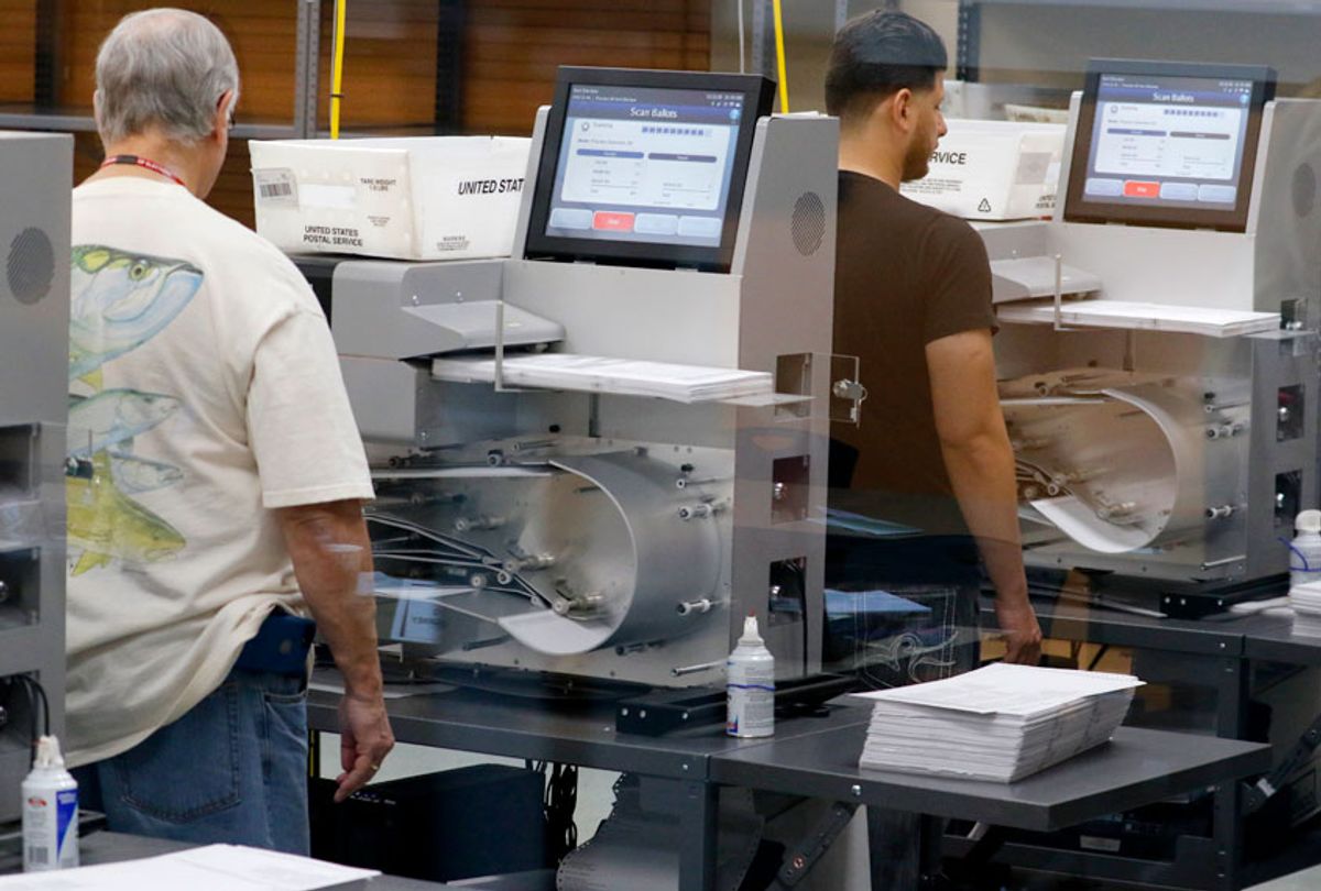 Elections staff load ballots into machine as recounting begins at the Broward County Supervisor of Elections Office on November 11, 2018 in Lauderhill, Florida (AP/Joe Skipper)