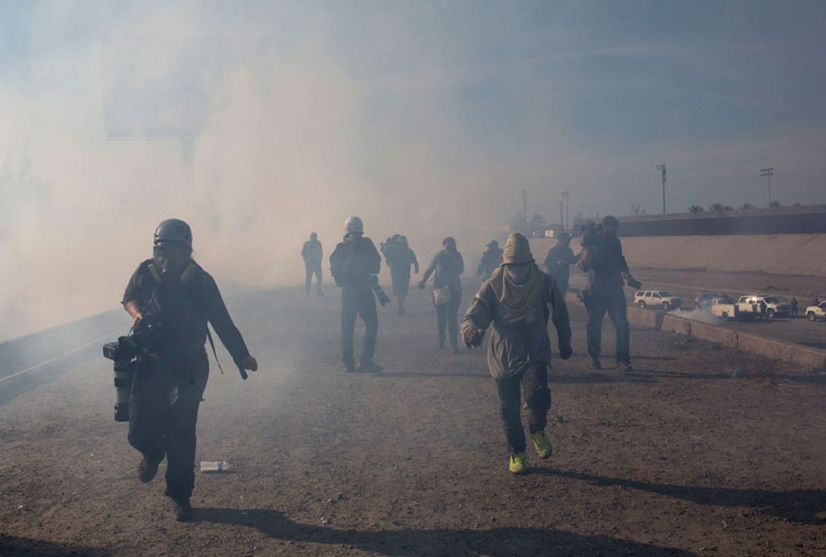 Migrants run from tear gas launched by U.S. agents after a group of migrants got past Mexican police at the Chaparral crossing in Tijuana, Mexico, Sunday, Nov. 25, 2018.  (AP/Rodrigo Abd)