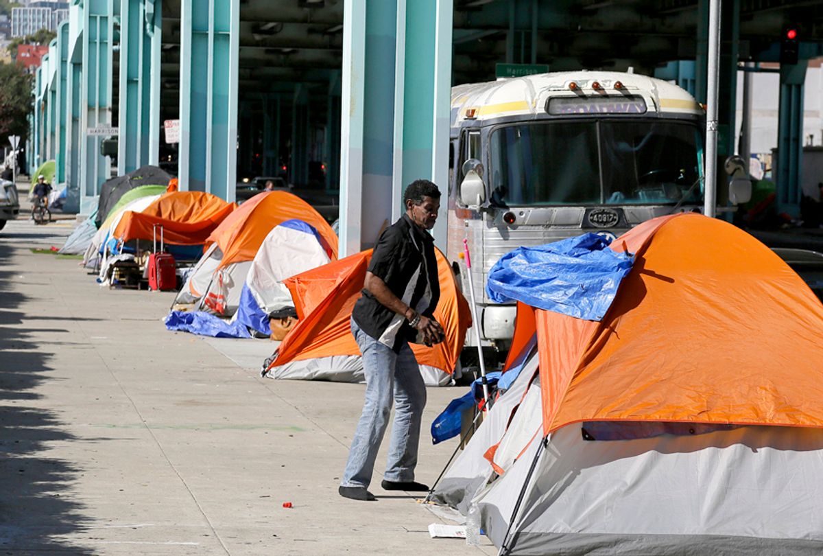 A man stands outside his tent on Division Street in San Francisco. (AP/Eric Risberg)