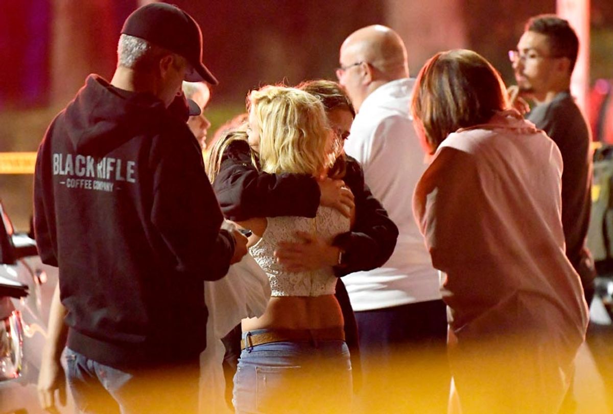 People comfort each other as they stand near the scene Thursday, Nov. 8, 2018, in Thousand Oaks, Calif., where a gunman opened fire Wednesday inside a country dance bar crowded with hundreds of people on "college night," wounding multiple people including a deputy who rushed to the scene. (AP/Mark J. Terrill)