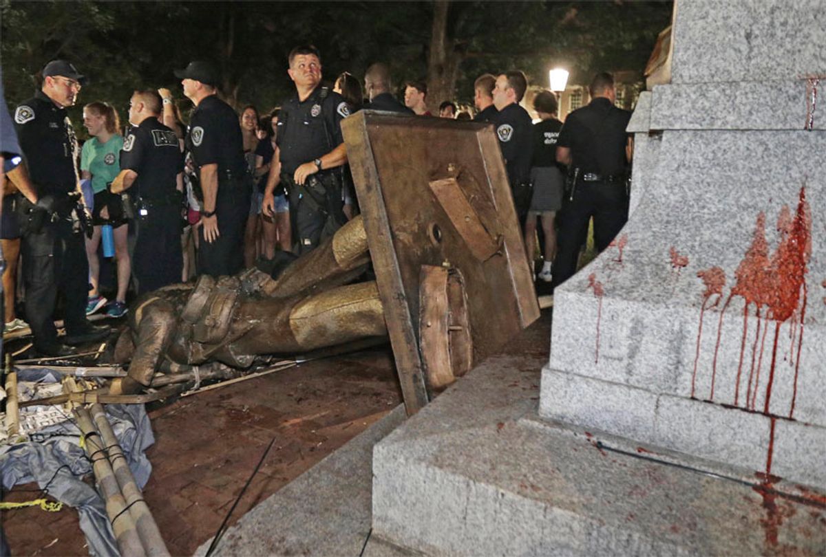 FILE - In this Aug. 20, 2018, file photo, police stand guard after the confederate statue known as Silent Sam was toppled by protesters on campus at the University of North Carolina in Chapel Hill, N.C. Leaders of North Carolina’s flagship university are meeting to decide the fate of a Confederate monument torn down by protesters. The chancellor and trustees of the University of North Carolina at Chapel Hill were finalizing a plan Monday, Dec. 3, for the century-old bronze statue known as “Silent Sam.” (AP Photo/Gerry Broome, File) (AP)