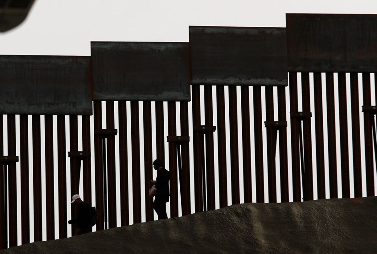 Men walk near the US-Mexico border fence as seen from Tijuana, Baja California state, Mexico on January 17, 2019. (Getty/Guillermo Arias)