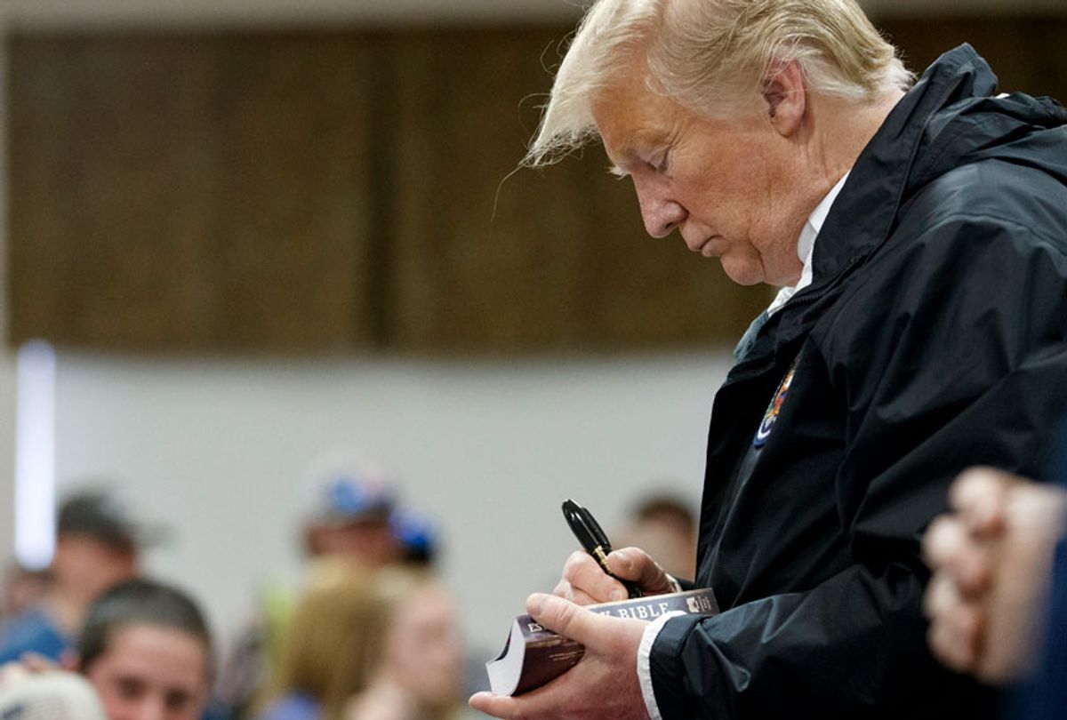 Donald Trump signs a Bible as he greets people at Providence Baptist Church in Smiths Station, Ala., Friday, March 8, 2019, during a tour of areas where tornados killed 23 people in Lee County, Ala. (AP/Carolyn Kaster)