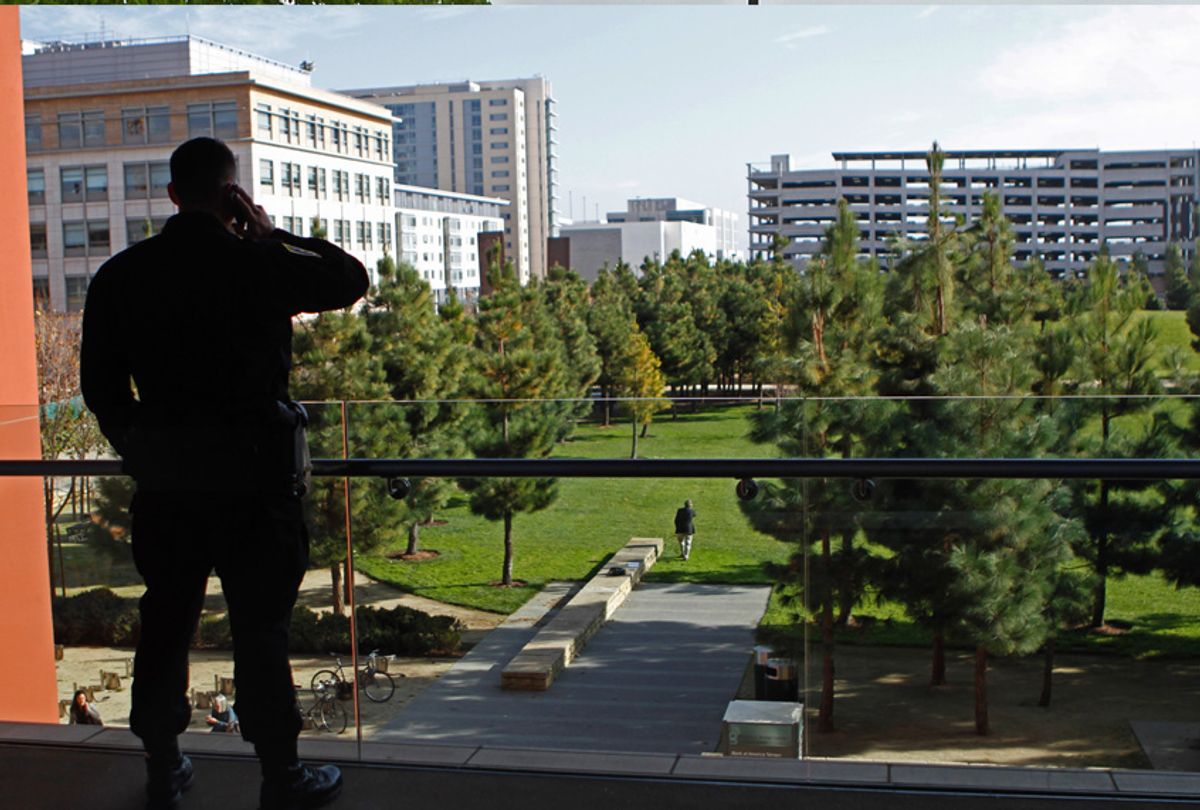 A University of California San Francisco police officer makes a phone call as he stands watch overlooking the Mission Bay campus Thursday, Nov. 18, 2010, during a UC Board of Regents meeting in San Francisco.  (AP Photo/Ben Margot) ((AP Photo/Ben Margot))