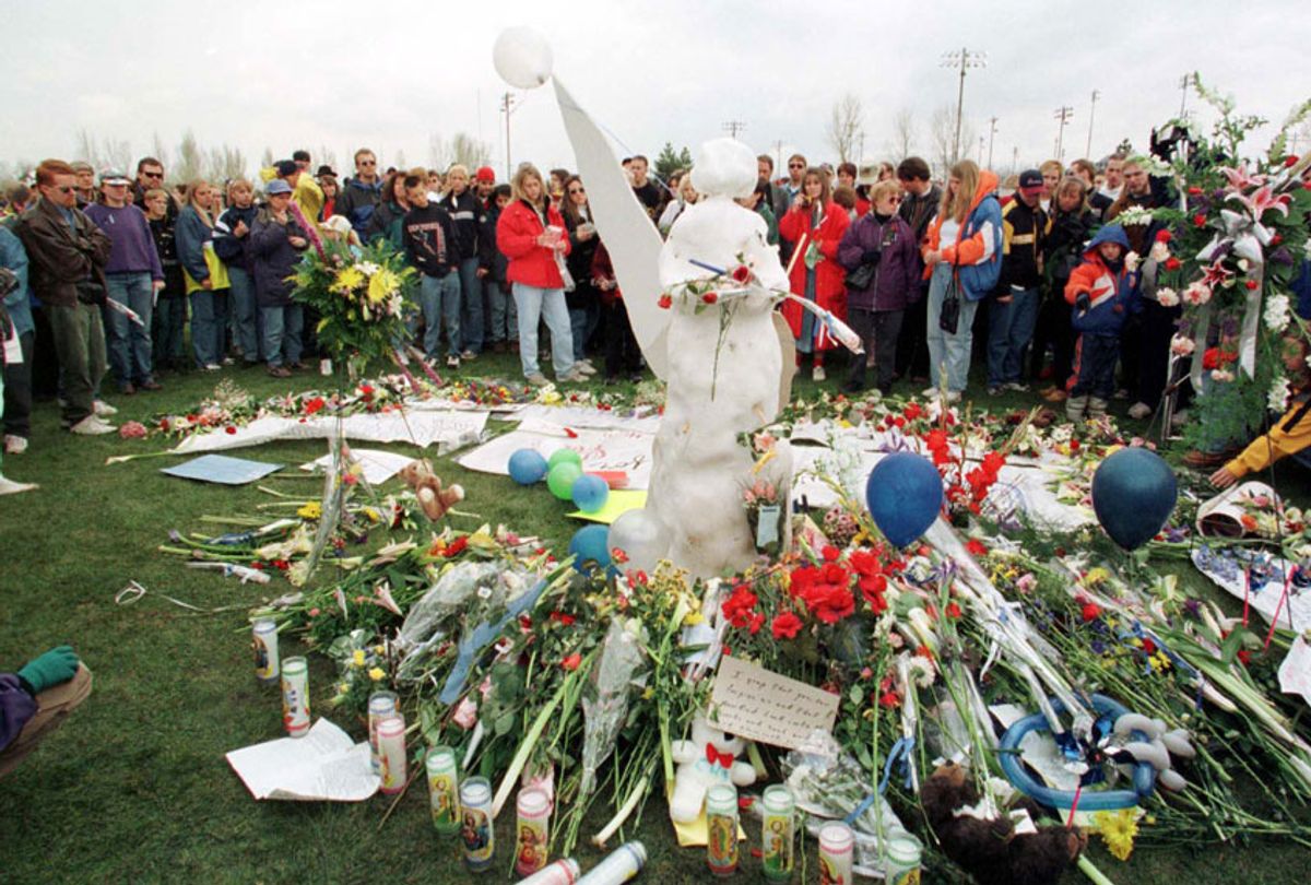 A large crowd circles an angel made of snow leaving flowers during a memorial service 25 April 1999 in rememberance of the students who were killed in the shooting at Columbine High School in Littleton, Colorado. (Getty/Mark Leffingwell)