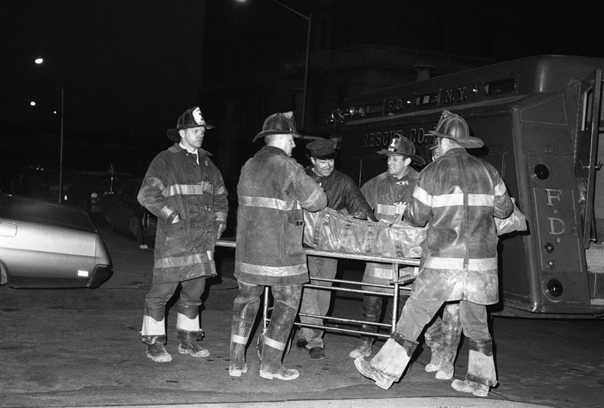 Firefighters place the body of a third victim of the Greenwich Village townhouse explosion on a cart at New York's Bellevue Hospital, March 14, 1970.  (AP Photo/TC)