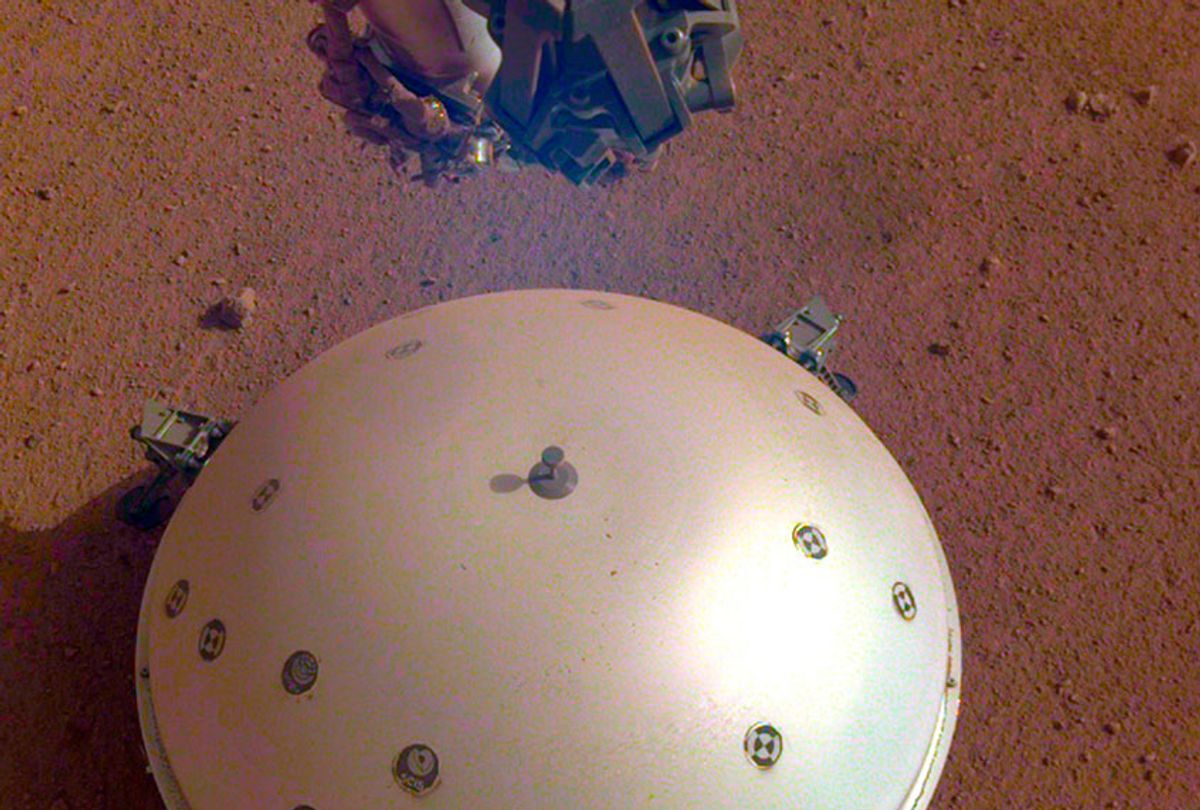This photo made available by NASA on Tuesday, April 23, 2019 shows the InSight lander's domed wind and thermal shield which covers a seismometer on the 110th Martian day, or sol, of the mission. On Tuesday, the space agency announced the instrument picked up a gentle rumble, believed to be the first marsquake ever detected.  (NASA/JPL-Caltech via AP)