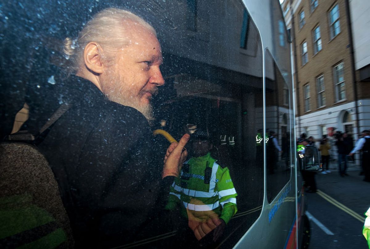 Julian Assange gestures to the media from a police vehicle on his arrival at Westminster Magistrates court on April 11, 2019 in London, England. (Getty/Jack Taylor)