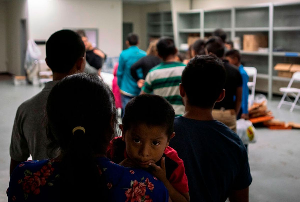 A Guatemalan boy looks over his mother's shoulder while waiting in line for food at the Casa del Refugiado, or The House of Refugee, a new centre opened by the Annunciation House to help the large flow of migrants being released by the United States Border Patrol and Immigration and Customs Enforcement in El Paso, Texas on April 24, 2019. (Getty/Paul Ratje)