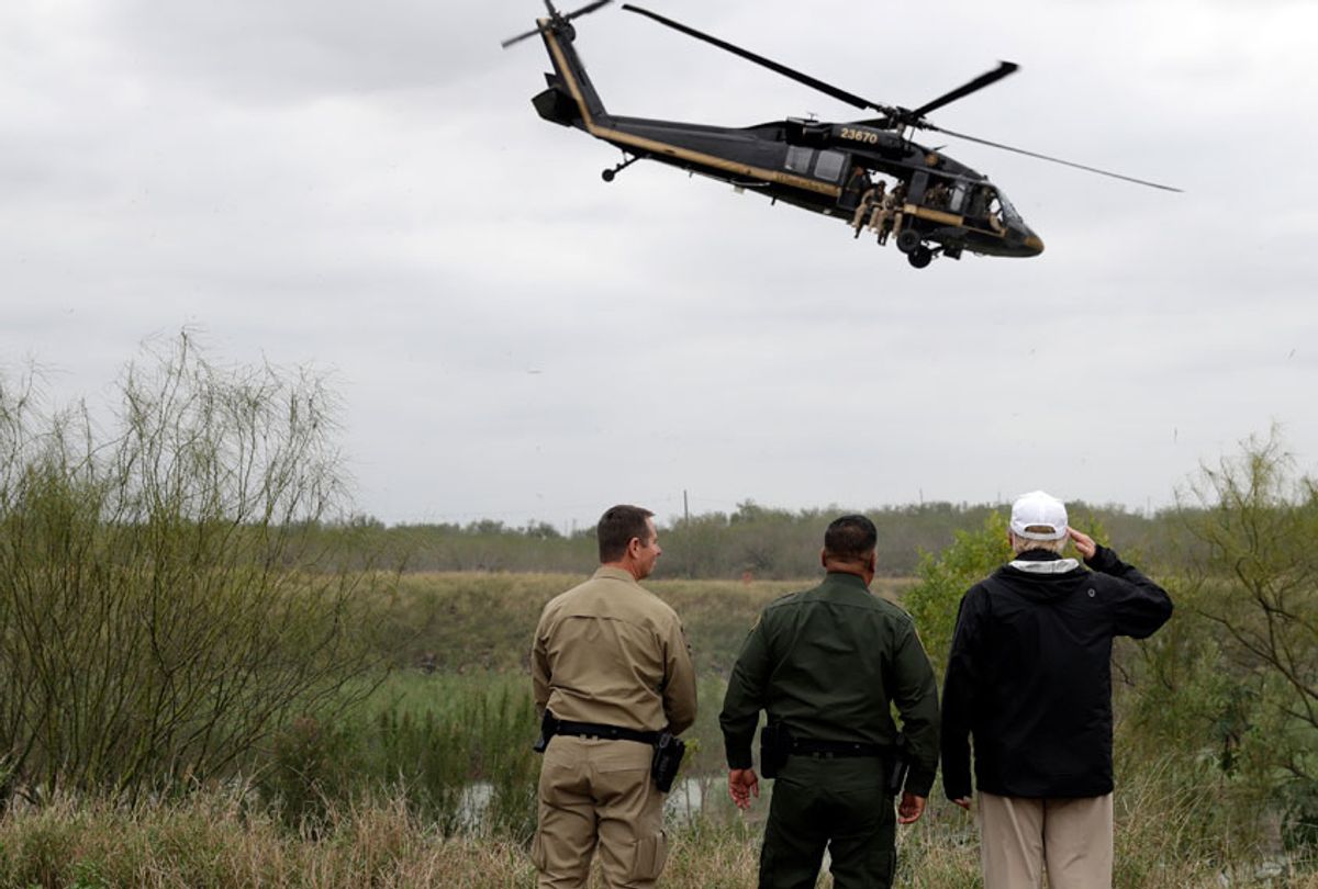 Donald Trump salutes as a U.S. customs and Border Protection helicopter passes as he tours the U.S. border with Mexico at the Rio Grande on the southern border, Thursday, Jan. 10, 2019, in McAllen, Texas. (AP/Evan Vucci)