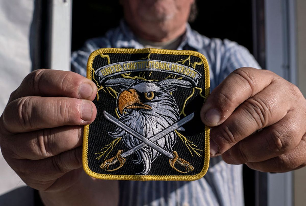 A member of United Constitutional Patriots New Mexico Border Ops militia team shows their group's patch outside their camper in Anapra, New Mexico on March 20, 2019. (Getty/Paul Ratje)