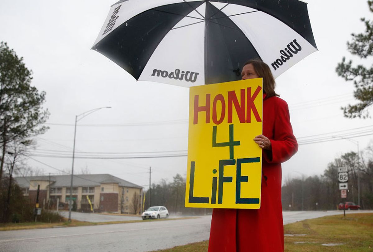 In this photo taken Feb. 22, 2016, Ellie Hermann, stands near the street, protesting the West Alabama Women’s Center, in Tuscaloosa, Ala. (AP/Brynn Anderson)