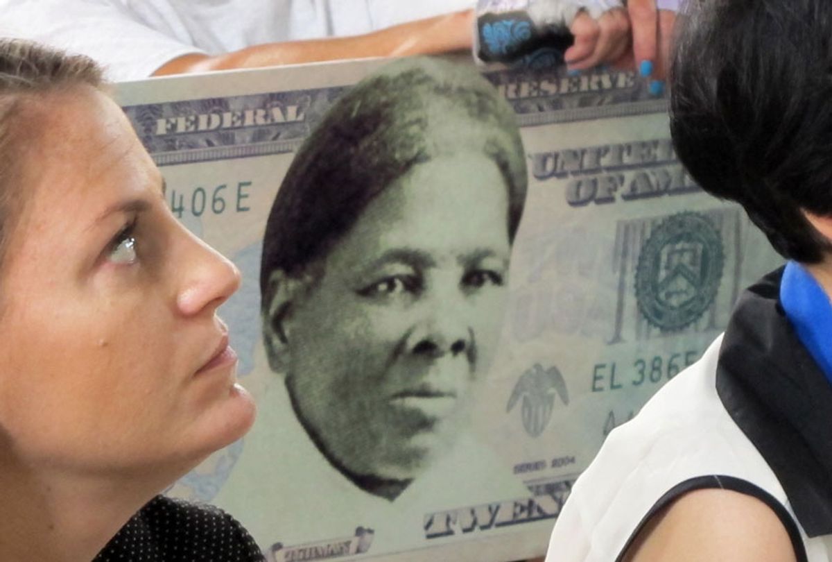 a woman holds a sign supporting Harriet Tubman for the $20 bill during a town hall meeting at the Women's Rights National Historical Park in Seneca Falls, N.Y., Aug. 31, 2015. (AP/Carolyn Thompson)