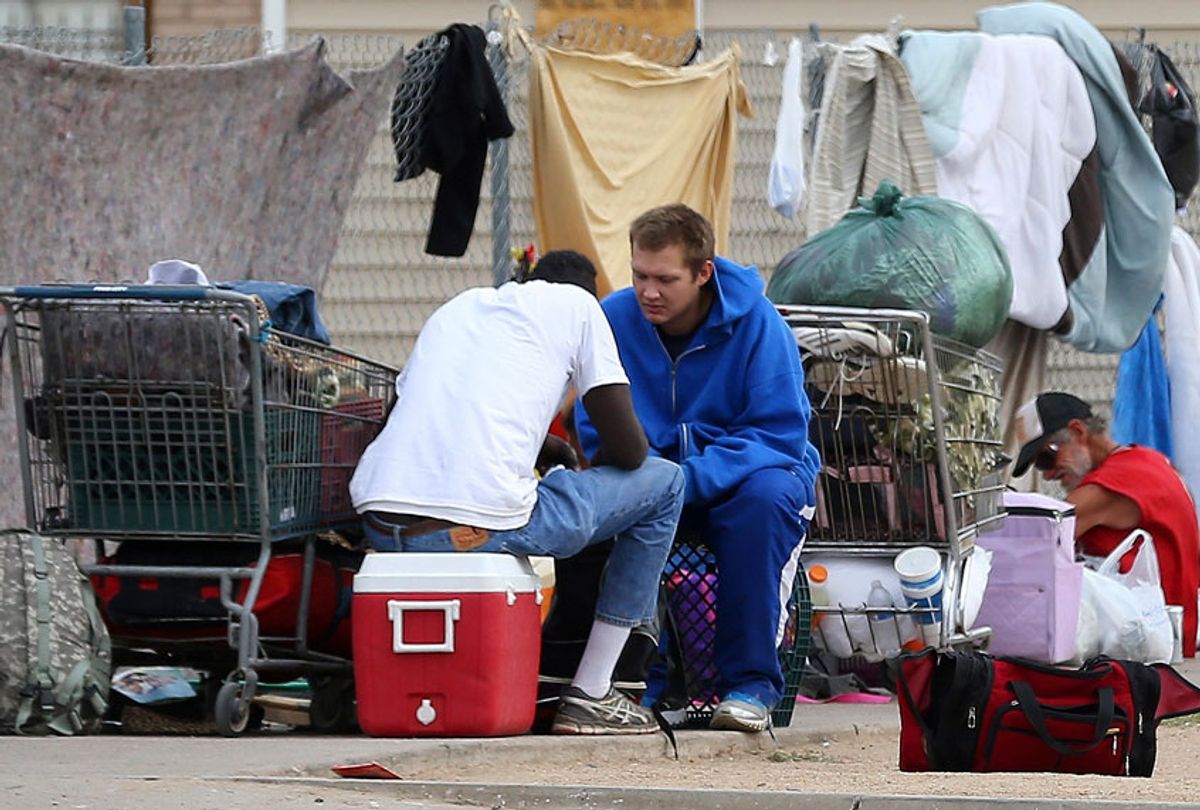 In this May 2, 2019, photo homeless people gather on the sidewalk at an encampment in Phoenix. (AP/Ross D. Franklin)