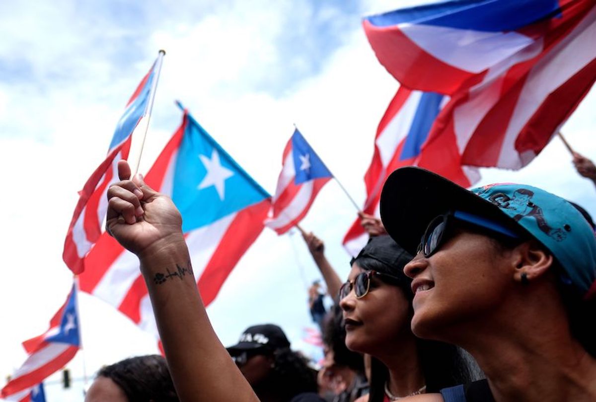 Demonstrators wave flags as they participate in a march the day after the governor of Puerto Rico, Ricardo Rossello, resigned from his charge in San Juan, on July 25, 2019.  (Ricardo Arduengo/AFP/Getty Images)