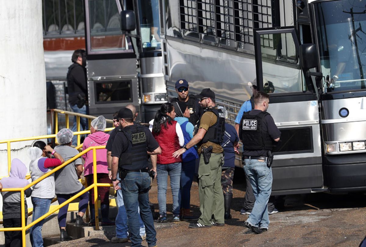 Handcuffed female workers are escorted into a bus for transportation to a processing center following a raid by U.S. immigration officials at a Koch Foods Inc., plant in Morton, Mississippi, Wednesday, Aug. 7, 2019. (AP/Rogelio V. Solis)