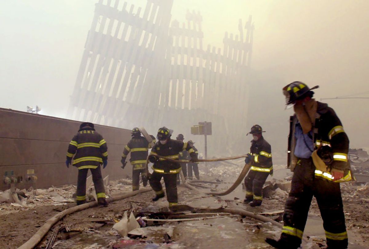 With the skeleton of the World Trade Center twin towers in the background, New York City firefighters work amid debris on Cortlandt St. after the terrorist attacks of Tuesday, Sept. 11, 2001. (AP Photo/Mark Lennihan)