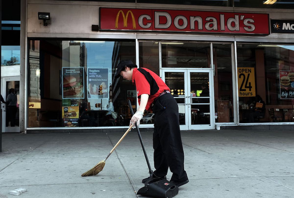 A McDonald's employee sweeps up outside the restaurant on April 15, 2015 in New York, United States. (Spencer Platt/Getty Images)