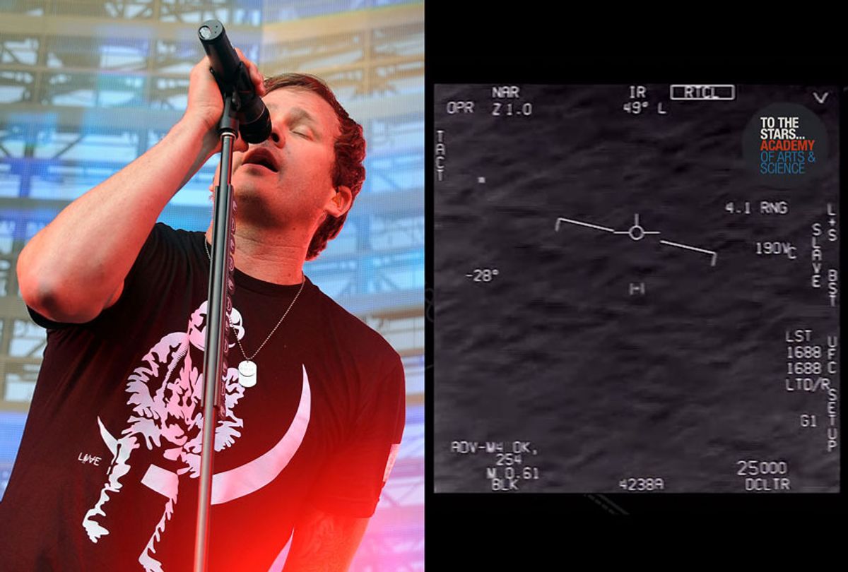 Tom DeLonge beside footage captured by a U.S. Navy F/A-18 Super Hornet using the Raytheon ATFLIR Pod that was being operated by a highly trained aerial observer and weapons system operator whom the government has spent millions of dollars to train. The footage reveals a Navy encounter that occurred off the East Coast of the United States in 2015 and the object in view remains unidentified (AP Photo/Katy Winn/U.S. Navy/To The Stars Academy)