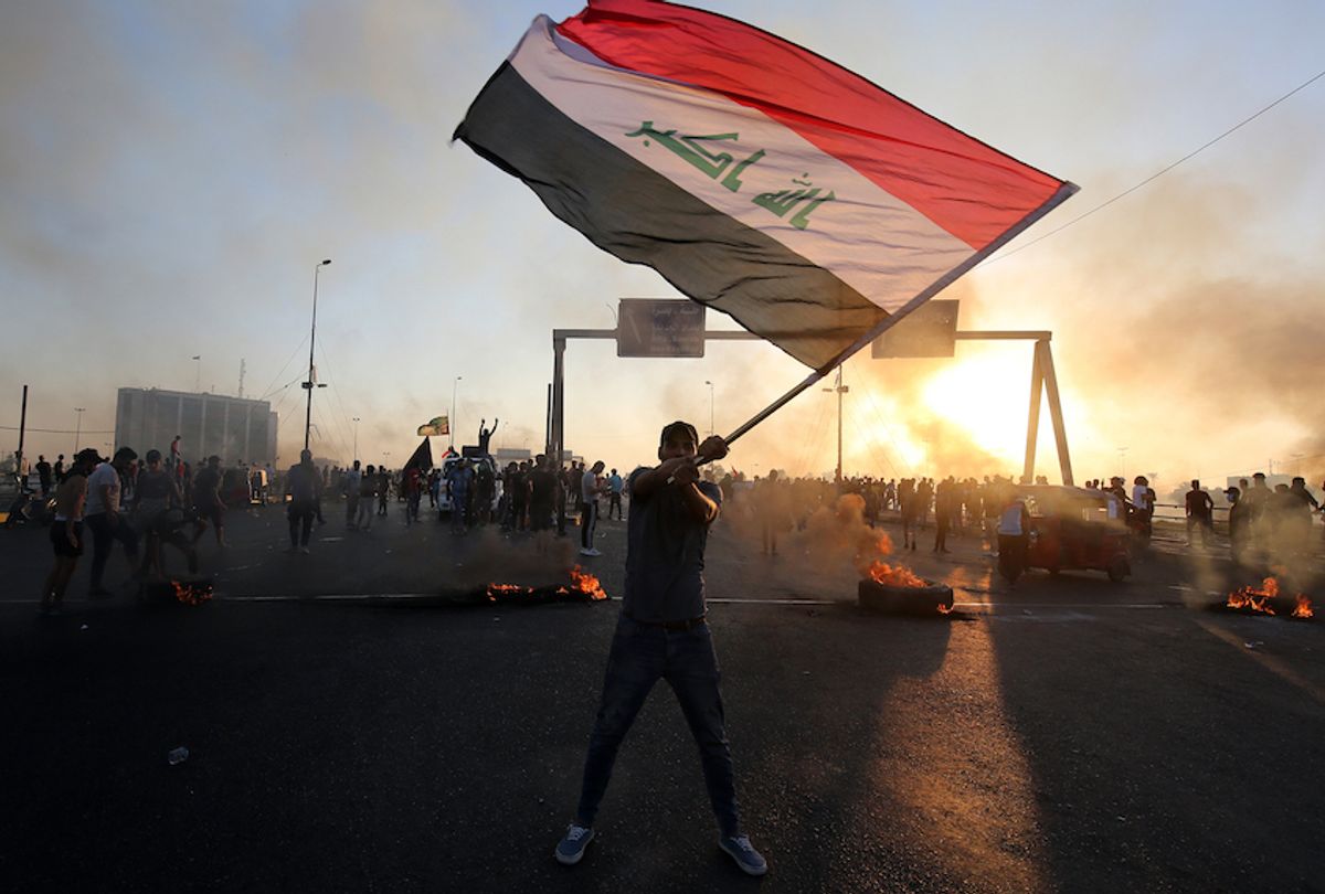 TOPSHOT - An Iraqi protester waves the national flag during a demonstration against state corruption, failing public services, and unemployment, in the Iraqi capital Baghdad on October 5, 2019. - Renewed protests took place under live fire in Iraq's capital and the country's south Saturday as the government struggled to agree a response to days of rallies that have left nearly 100 dead. The largely spontaneous gatherings of demonstrators -- whose demands have evolved since they began on Tuesday from employment and better services to fundamental government change -- have swelled despite an internet blackout and overtures by the country's elite. Hours after a curfew in Baghdad was lifted on Saturday morning, dozens of protesters rallied around the oil ministry in the capital, facing live rounds fired in their direction, an AFP photographer said. (Photo by AHMAD AL-RUBAYE / AFP) (Photo by AHMAD AL-RUBAYE/AFP via Getty Images) (Ahmad Al-Rubaye/ Afp via Getty Images)