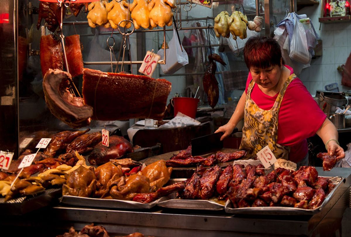 A woman arranges cooked meat at an open-front food store. (Alex Ogle/AFP/Getty Images)