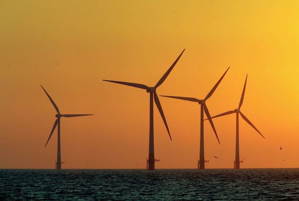 GREAT YARMOUTH, ENGLAND - JULY 19: The sun starts to rise behind Britain's largest offshore wind farm off the Great Yarmouth coastline on July 19, 2006 in Norfolk, England. The 30 turbines cost GBP75million and can generate enough power for 41,000 homes are seen by supporters as a clean and green way to generate electricity and a way of cutting down on harmful green house gas emmissions. (Photo by Matt Cardy/Getty Images) (Matt Cardy/Getty Images)
