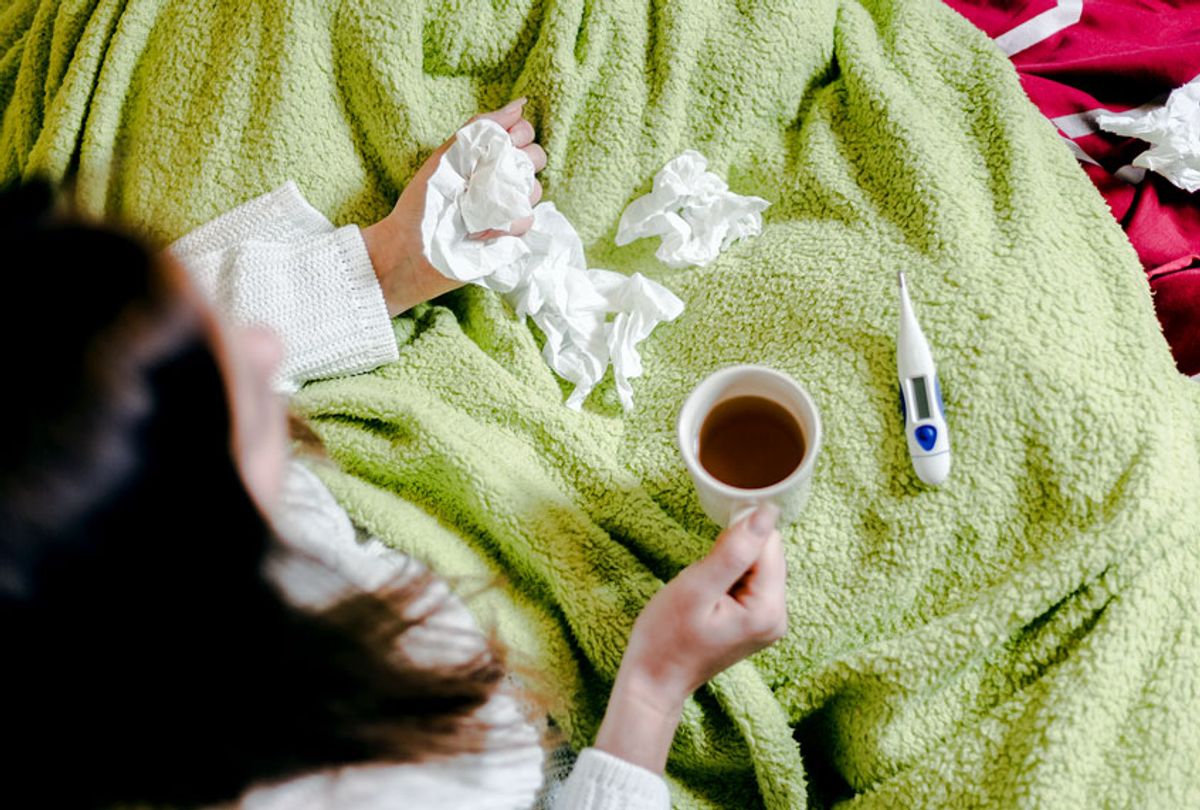 Sick in bed, with tissues and tea (Getty Images/sestovic)