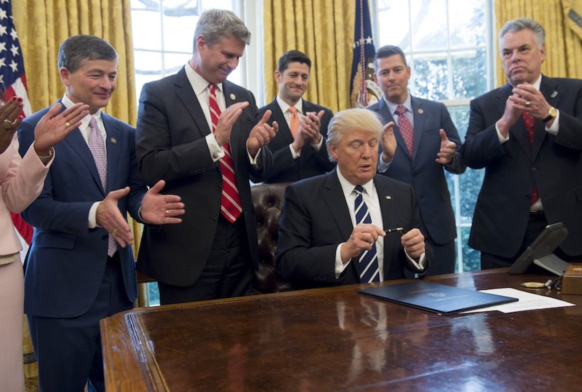 Lawmakers applaud as US President Donald Trump puts the cap on his pen after signing House Joint Resolution 41, which removes some Dodd-Frank regulations on oil and gas companies, during a bill signing ceremony in the Oval Office of the White House in Washington, DC, February 14, 2017. / AFP / SAUL LOEB        (Photo credit should read SAUL LOEB/AFP/Getty Images) (Saul Loeb/AFP/Getty Images)