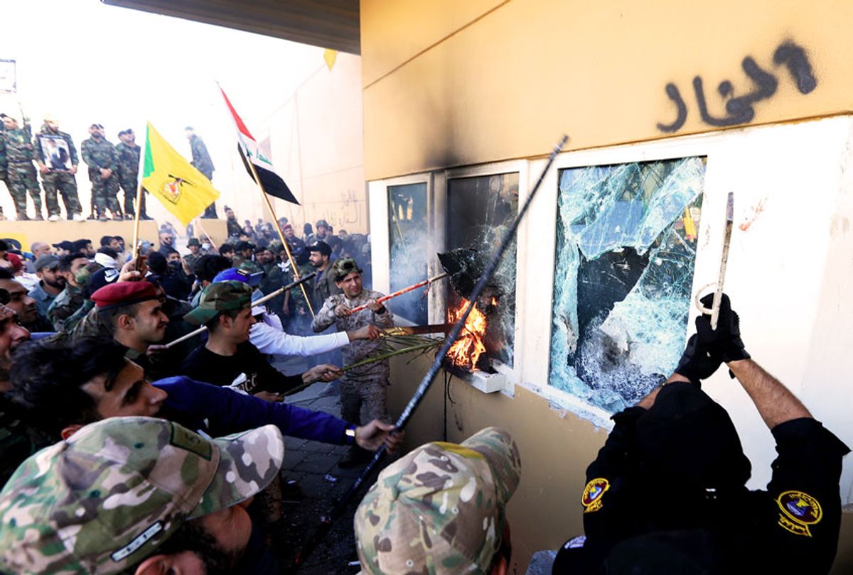 Outraged Iraqi protesters storm the U.S. Embassy in Baghdad, protesting Washington's attacks on armed battalions belong to Iranian-backed Hashd al-Shaabi forces on December 31, 2019. At least 25 people were killed in weekend U.S. airstrikes on positions of Kataib Hezbollah, an Iranian-backed militia group, in Iraq and Syria. Hundreds of Iraqi protesters gathered early Tuesday near the embassy to show their anger at the U.S. move. (Photo by  (Murtadha Sudani/Anadolu Agency via Getty Images)