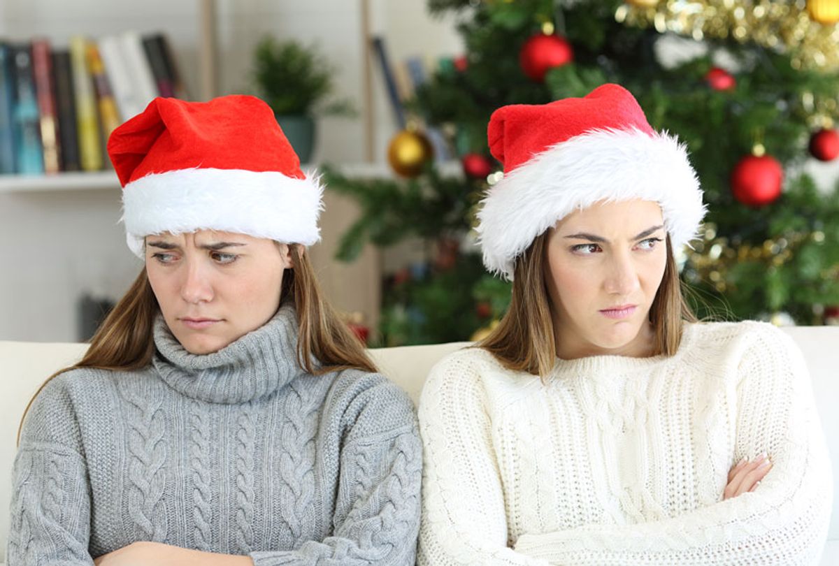 Angry sisters on Christmas sitting on a couch in the living room at home (Getty Images/Antonio Guillem)