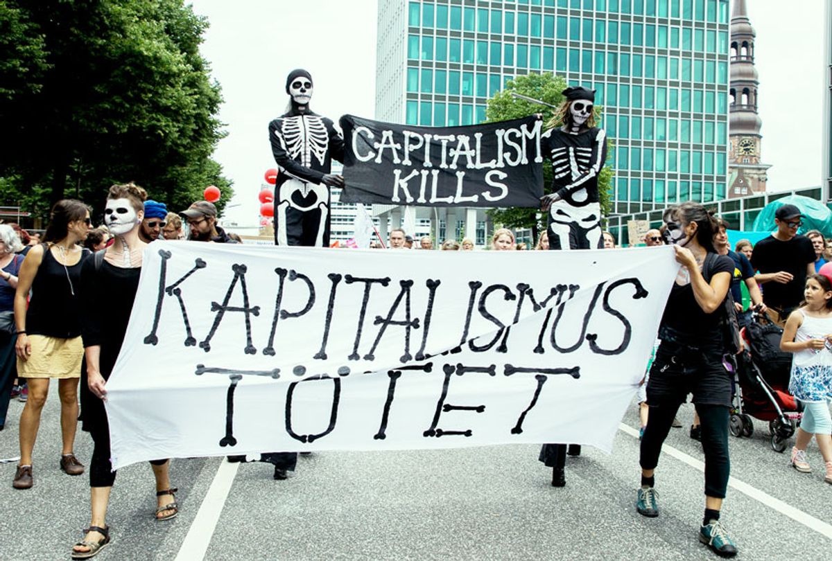 People holding a banner reading 'capitalism kills' attend a protest march against the G20 Summit with the topic 'Solidarity without borders instead of G20' in Hamburg, Germany on July 8, 2017. Organizerg spoke of about 70.000 participants to the demonstration. (Emmanuele Contini/NurPhoto via Getty Images)