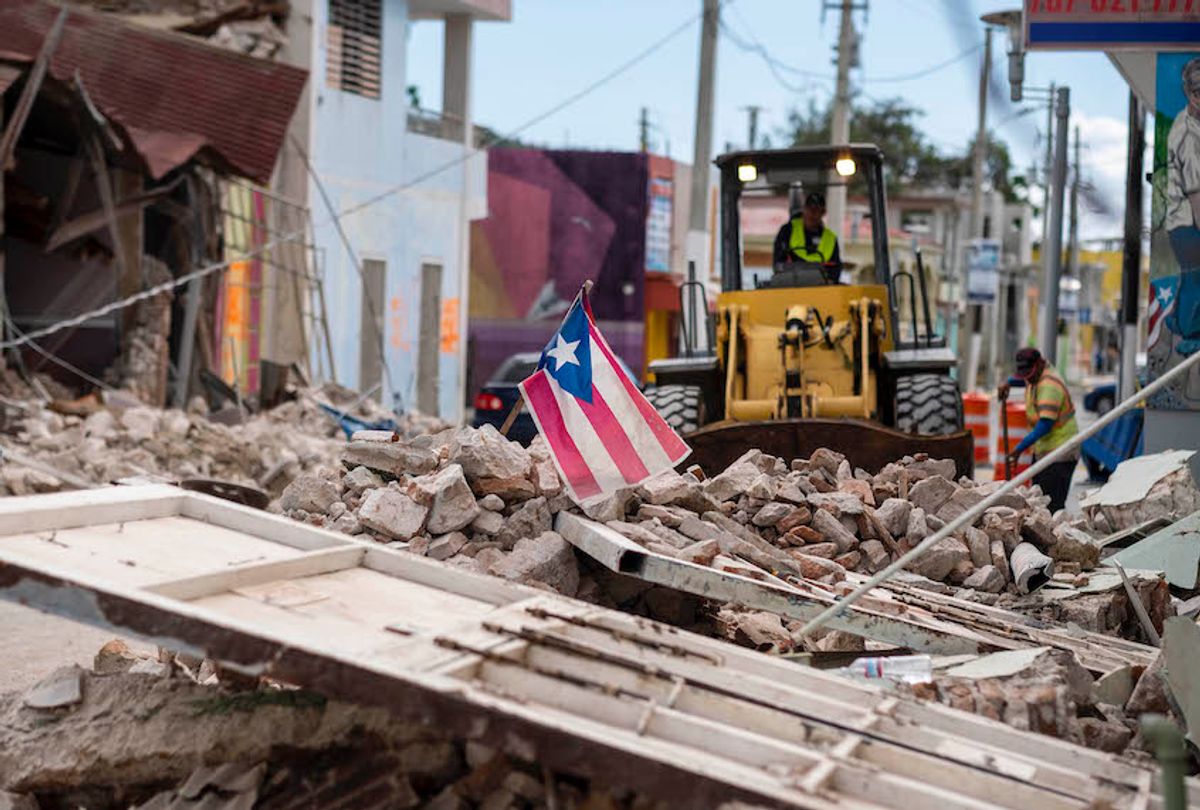 A Puerto Rican flag waves on top of a pile of rubble as debris is removed from a main road in Guanica, Puerto Rico on January 8, 2020. (Ricardo Arduengo/AFP via Getty Images)