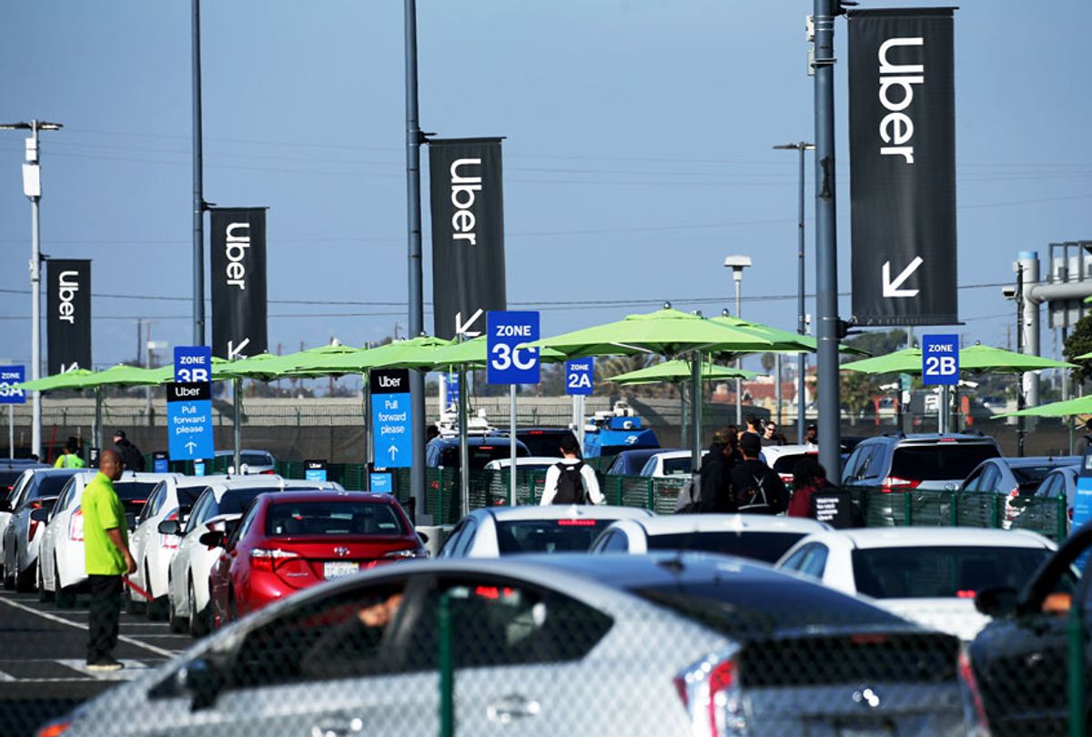 Uber vehicles are lined up at the  ride-hail passenger pickup lot at an airport (Mario Tama/Getty Images)