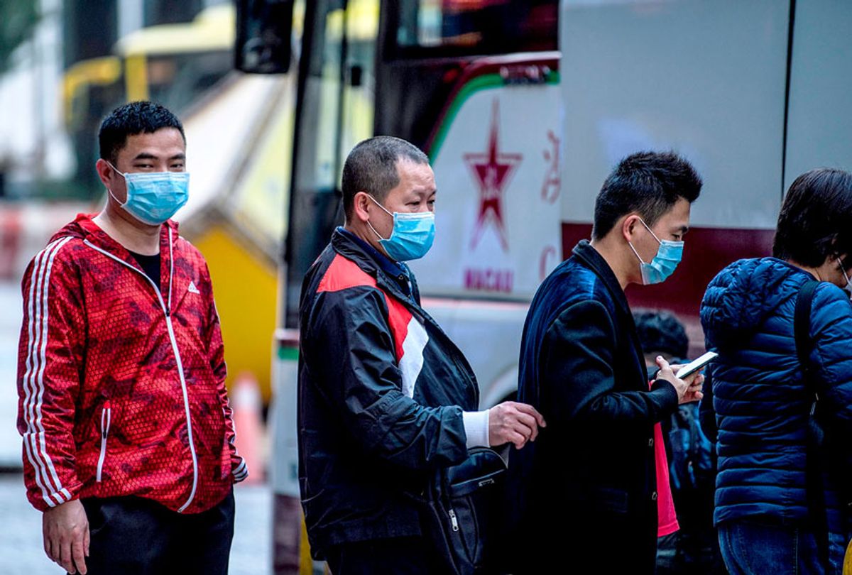 Tourists wear face masks as they prepare to board their tour bus outside the New Orient Landmark hotel in Macau on January 22, 2020, after the former Portuguese colony reported its first case of the new SARS-like virus that originated from Wuhan in China. (ANTHONY WALLACE/AFP via Getty Images)