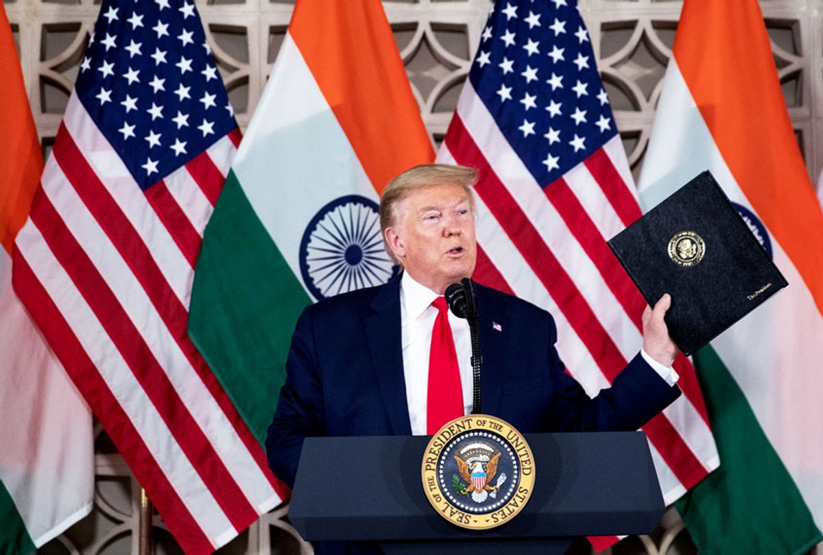U.S.President Donald Trump holds up his prepared speech that he didn't use as he speaks with business leaders at a roundtable event at Roosevelt House, Tuesday, Feb. 25, 2020, in New Delhi, India.  (AP Photo/Alex Brandon)