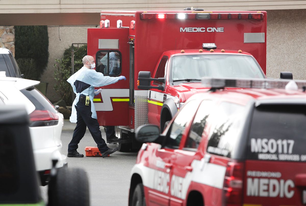 Ambulance staff prepare to transport a patient from the Life Care Center nursing home where some patients have died from COVID-19 in Kirkland, Washington on March 5, 2020. (Jason Redmond / AFP via Getty)
