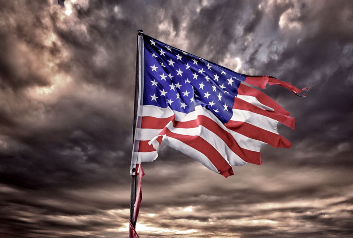 Tattered American flag flapping in ominous sky (Getty Images)