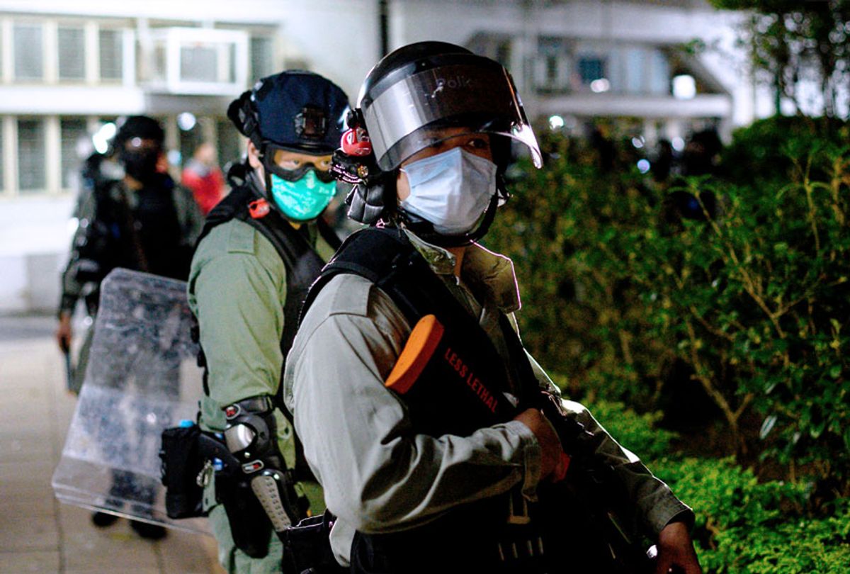 Riot police officers wearing face masks stand guard as residents protest against plans for an empty local housing estate to become a temporary quarantine camp for patients and frontline medical staff of a SARS-like virus outbreak which began in the Chinese city of Wuhan, in the Fanling district in Hong Kong on January 26, 2020. - Protesters threw petrol bombs on January 26 night at an empty public housing complex in Hong Kong that had been earmarked to become a temporary quarantine zone as the city battles the outbreak of a SARS-like virus.  (PHILIP FONG/AFP via Getty Images)