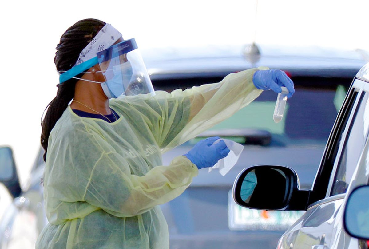 A health worker conducts COVID-19 tests at a drive-thru coronavirus testing site (AP Photo/John Raoux)