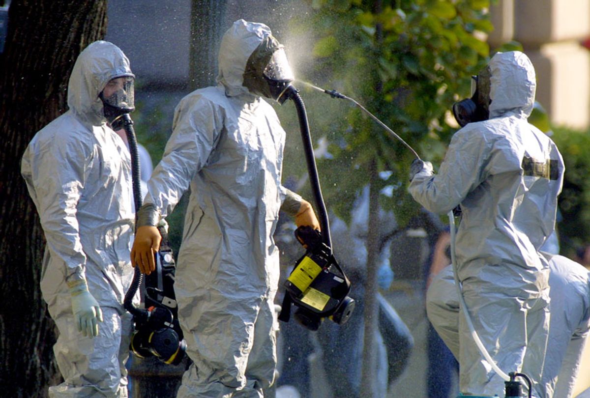 A hazardous materials worker sprays his colleagues on October 23, 2001, after they came out from an anthrax search at the Longworth House Office Building on Capitol Hill in Washington, DC. (Alex Wong/Getty Images)