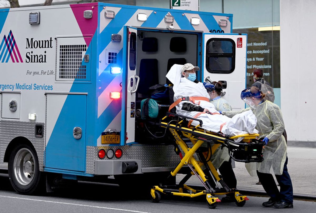 EMS workers wearing PPE load a COVID-19 patient into an ambulance in front of a CityMD amid the coronavirus pandemic on April 12, 2020 in New York City (Alexi Rosenfeld/Getty Images)