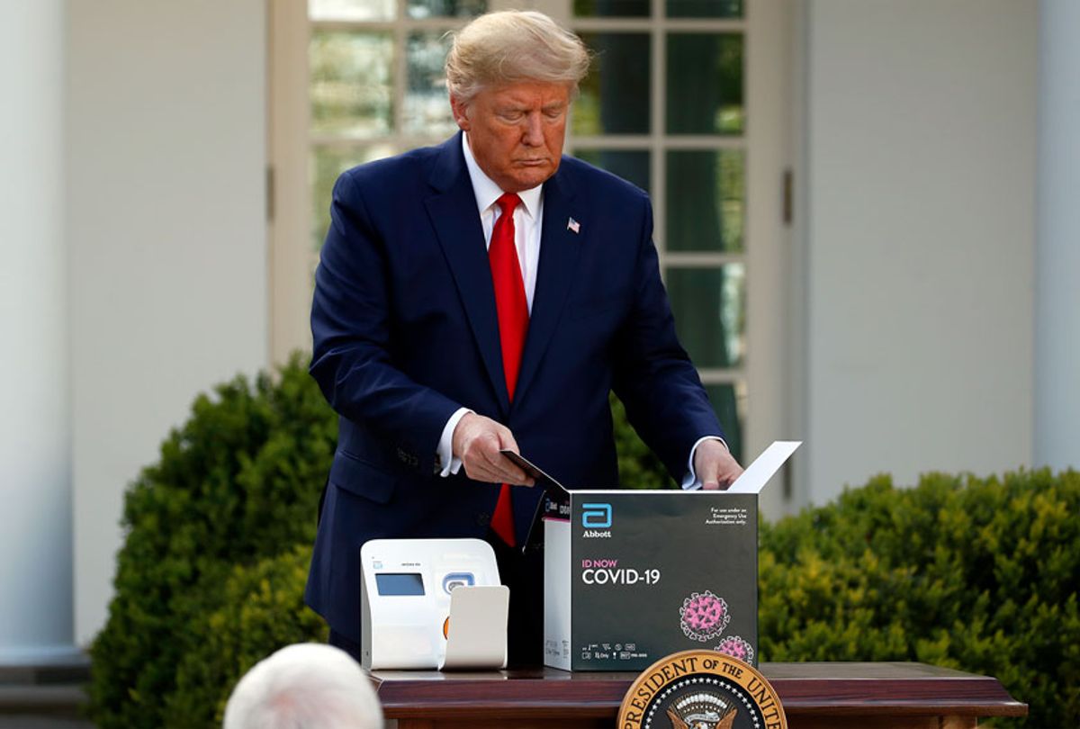 President Donald Trump opens a box containing an Abbott Labs testing kit during a coronavirus briefing at the White House in March.  (AP Photo/Alex Brandon)