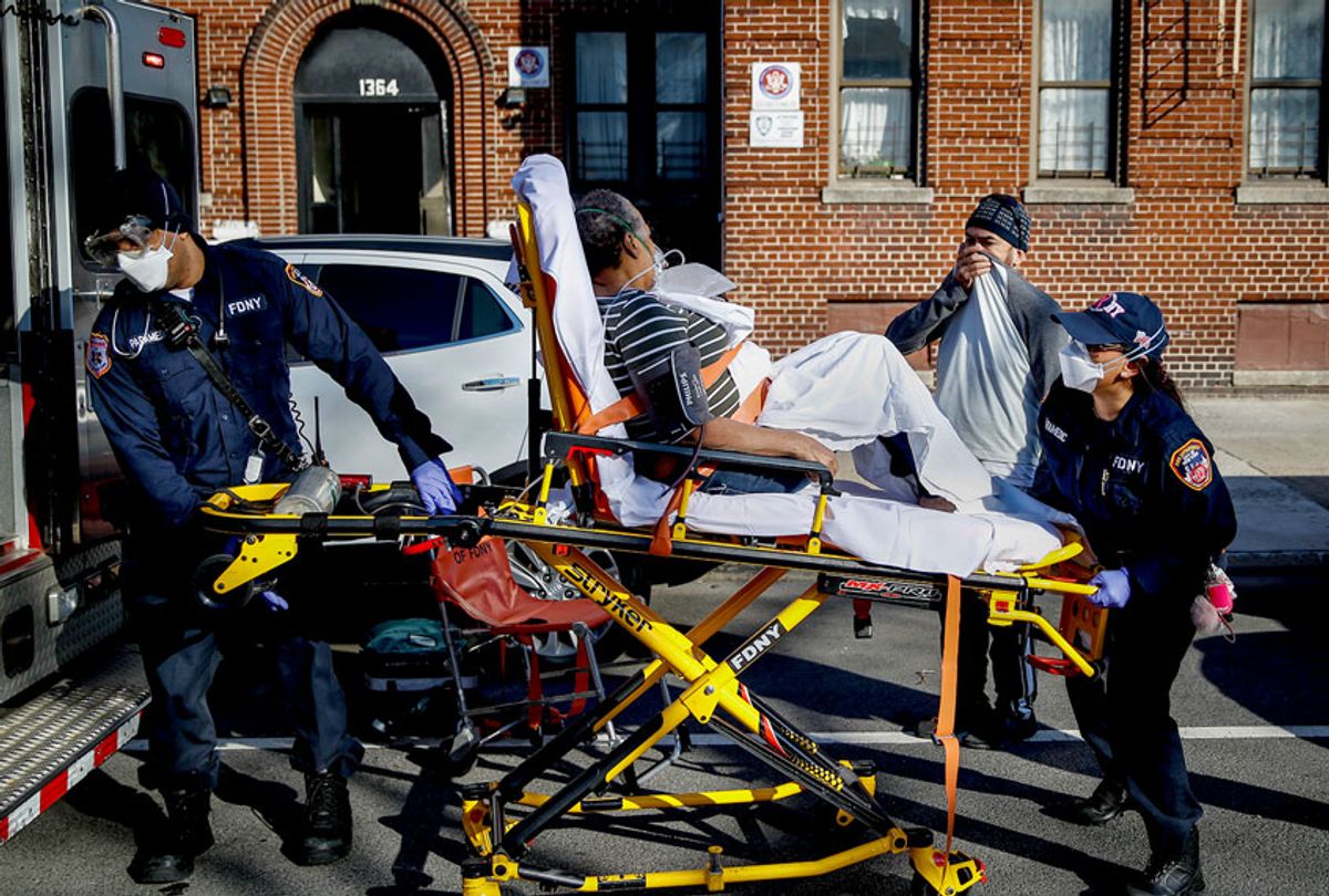 FDNY paramedics load an elderly patient into their ambulance on an emergency call during the novel Coronavirus pandemic in NYC (AP Photo/John Minchillo)