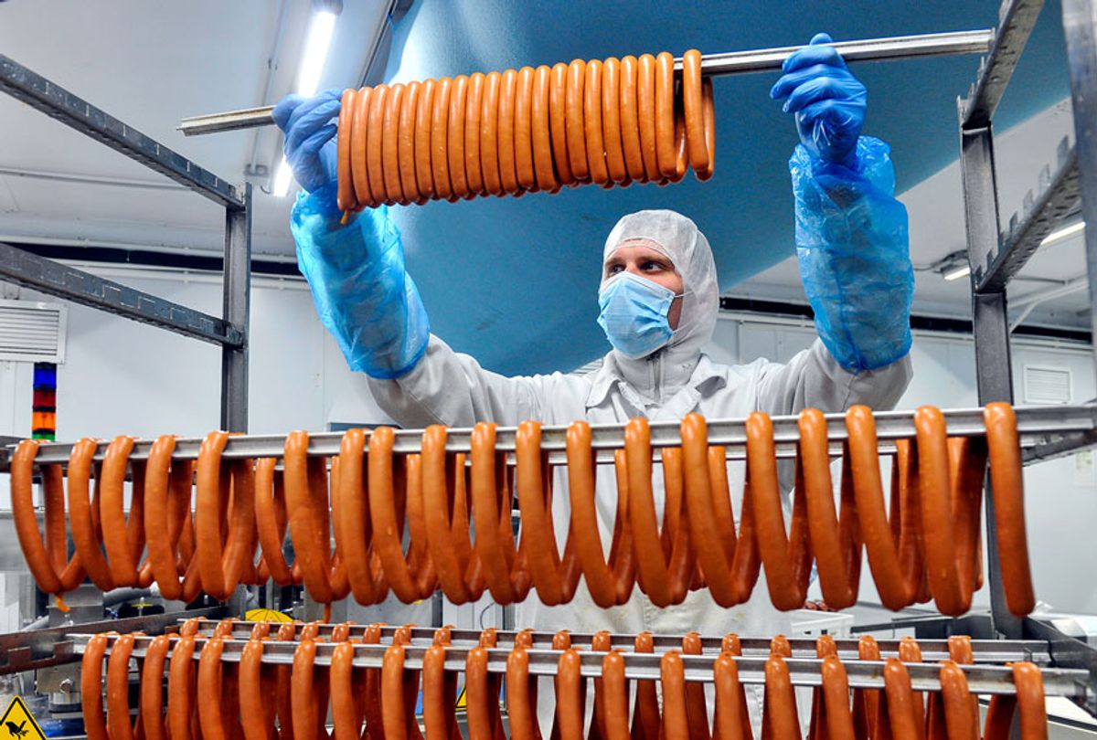 Worker in protective gear producing sausage at the Okraina meat processing plant in Murmansk.  (Lev Fedoseyev\TASS via Getty Images)