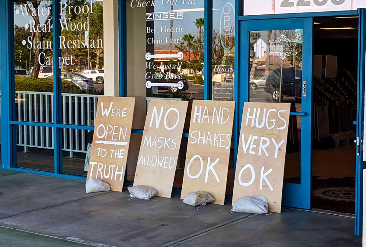A Flooring business put out signs that included messages like “No Masks Allowed,” “Handshakes OK,” and “Hugs Very OK.” (Twitter/@davidlparsons)