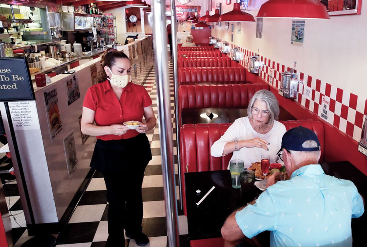 Lynn Tanner, center, and her husband Ryan, bottom right, are served lunch at Busy Bee Cafe Thursday, May 21, 2020, in Ventura, Calif. Much of the country remains unlikely to venture out to bars, restaurants, theaters or gyms anytime soon, despite state and local officials increasingly allowing businesses to reopen. (AP Photo/Marcio Jose Sanchez)
