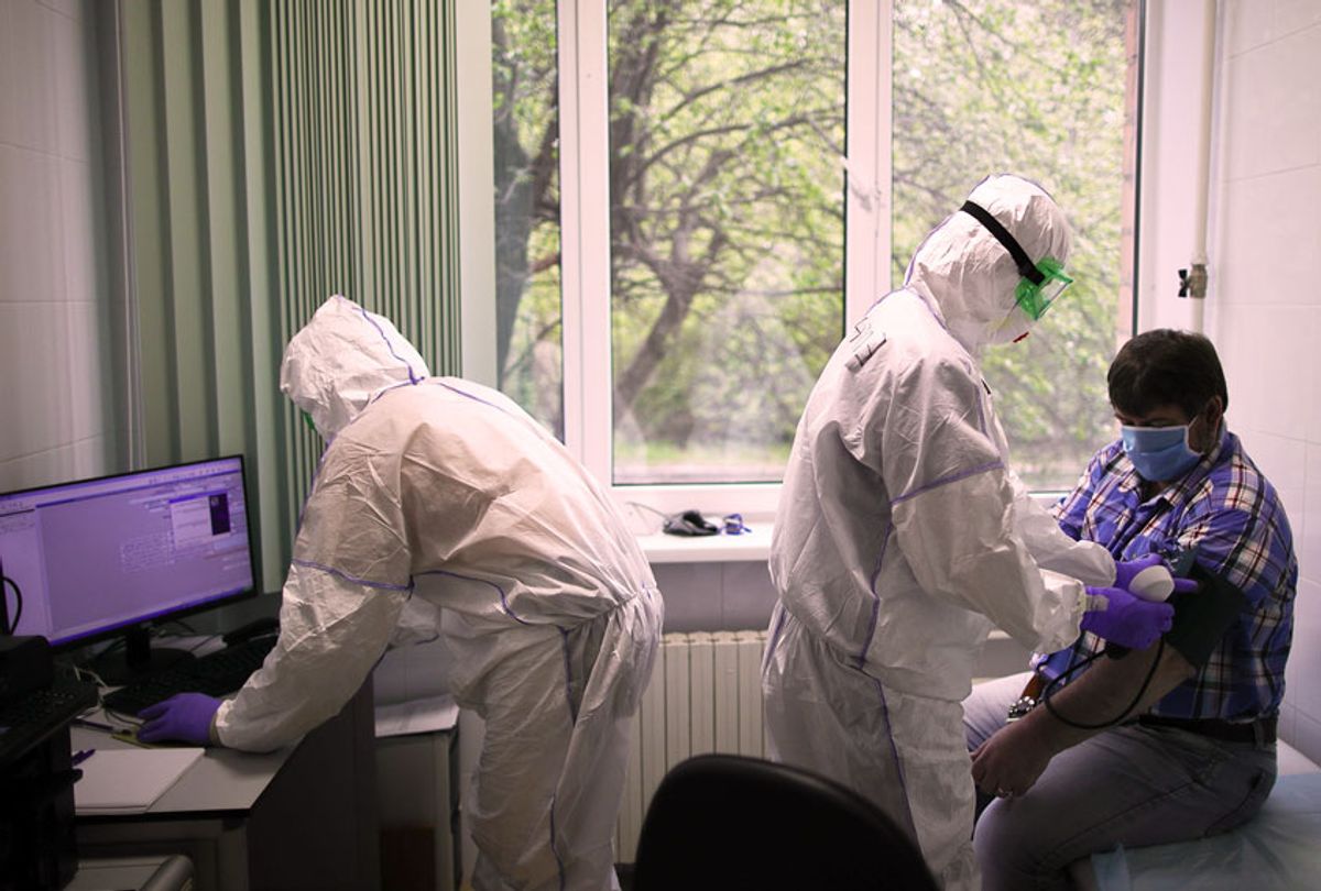 Employees and a patient at the Federal Clinical Center of Higher Medical Technologies of the Russian Federal Medical Biological Agency that treats COVID-19 patients, patients with suspected coronavirus and patients with viral community-acquired pneumonia. (Sergei Bobylev\TASS via Getty Images)
