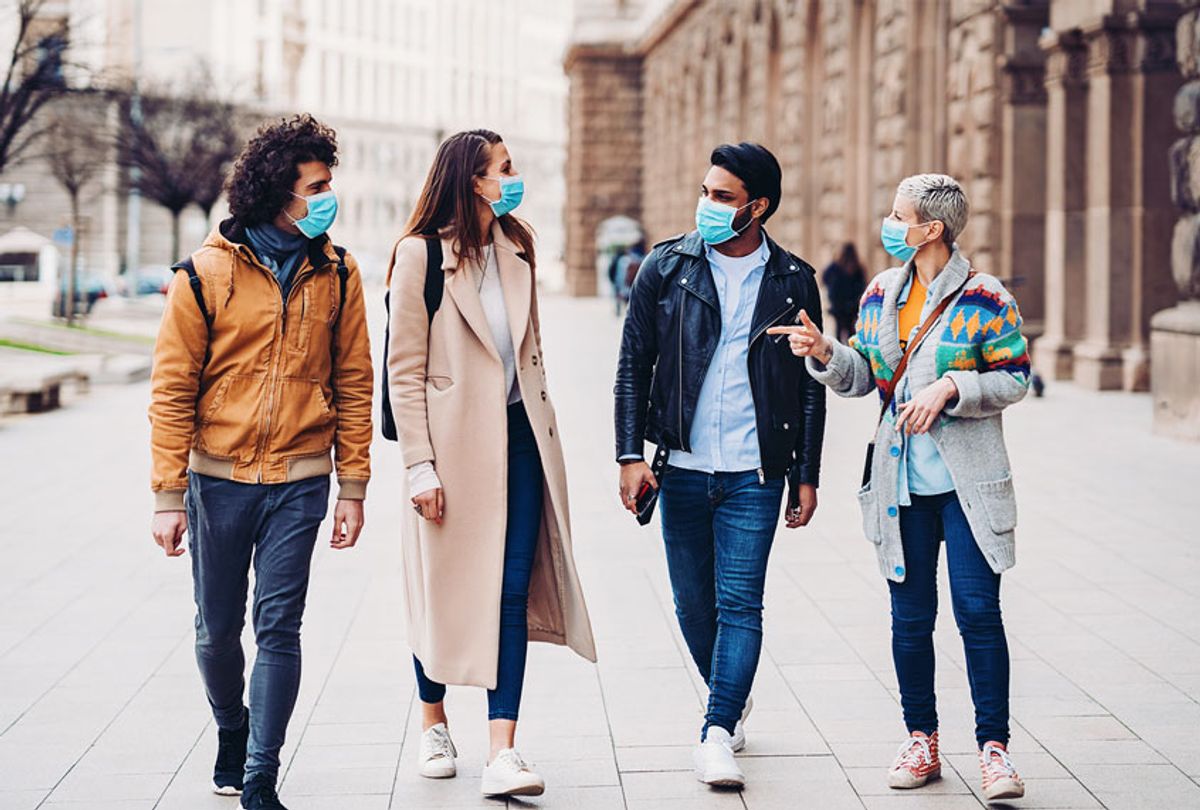 Group of people with protective masks walking outdoors in the city (Getty Images)